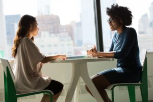 Zwei Frauen sitzen sich gegenüber und kommunizieren